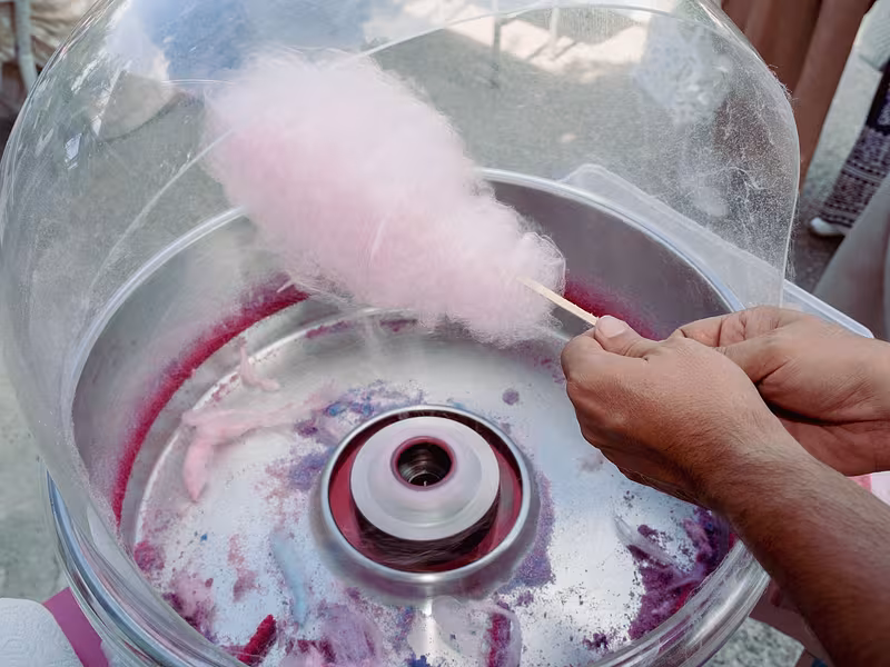 Máquina de algodón de azúcar preparando un algodón rosa durante una fiesta