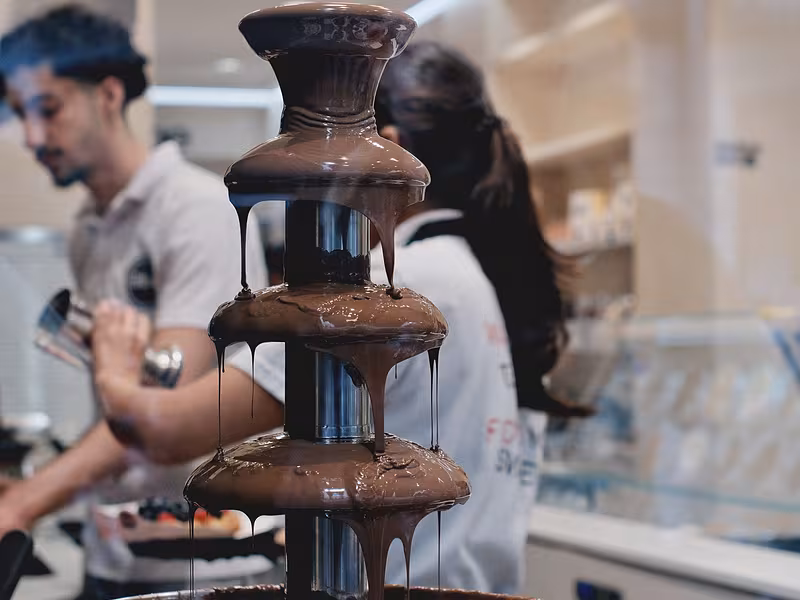 Fuente de chocolate en operación atendida por personal durante un evento