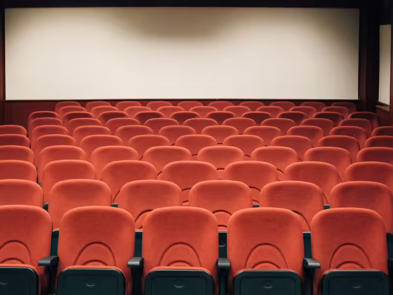 Auditorio con butacas vacías y una pantalla de gran formato al fondo del escenario
